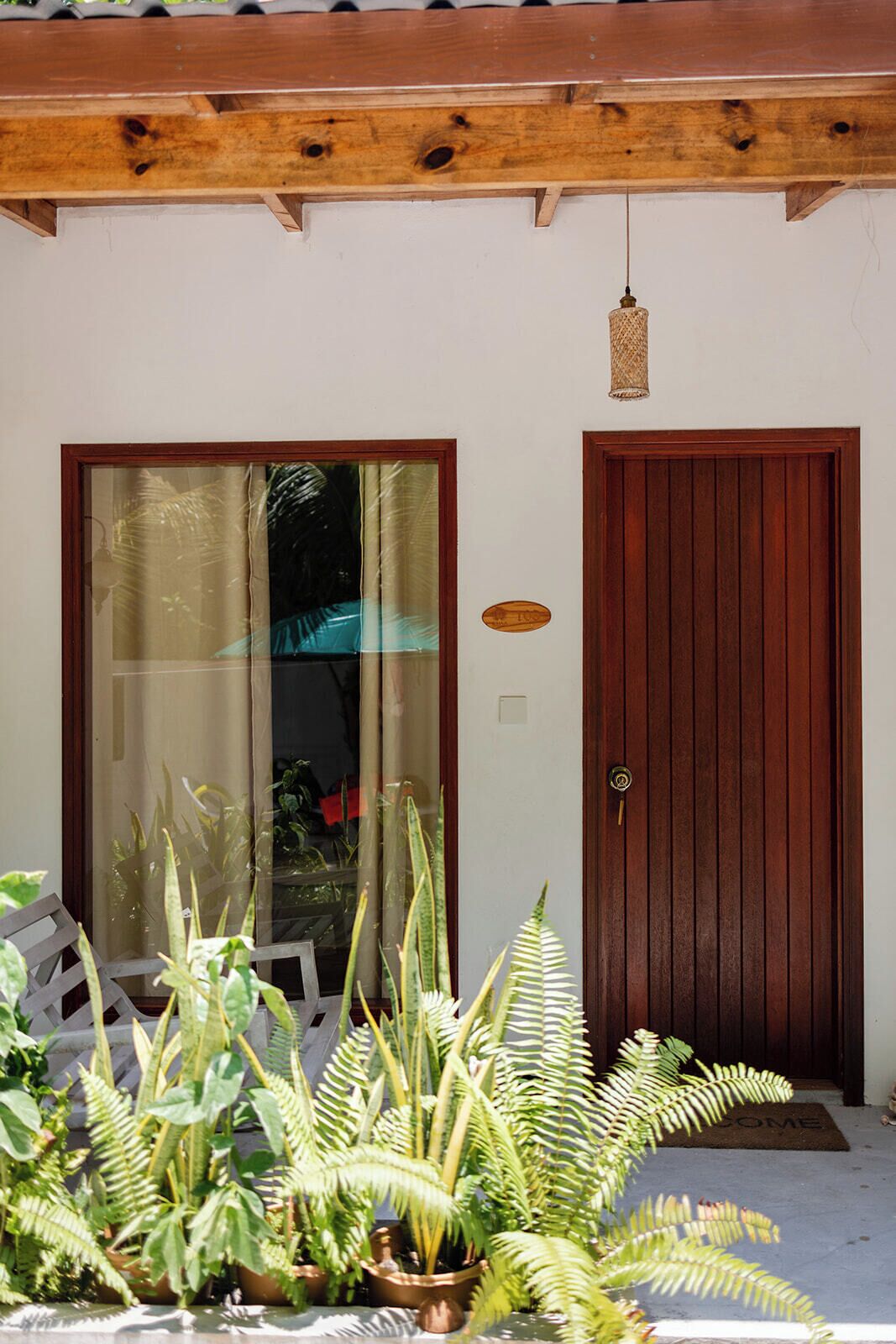 Uma porta de madeira com painel de vidro, moldura de madeira e um lustre.