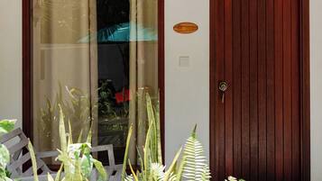 Uma porta de madeira com painel de vidro, moldura de madeira e um lustre.