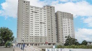A multi-story residential building with a uniform facade, numerous windows, and a central entrance. - Capital O 93516 Loftvilles City Residence (Tangerang)