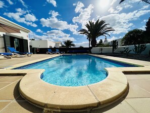 Relax by the clear pool surrounded by a cactus garden and lounge chairs on the tiled deck.