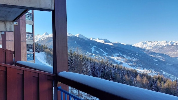 A mountain view from a balcony with a wooden railing, snow-covered trees, and distant snow-capped peaks. - 200m from resort center, 5th floor, swimming pool, balcony, tv, 30m², Les Arcs (Les Arcs)