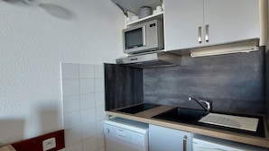 A compact kitchen with a microwave, a sink, and a dishwasher. - 200m from resort center, 5th floor, swimming pool, balcony, tv, 30m², Les Arcs (Les Arcs)