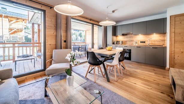 Una cocina moderna con armarios de madera y un comedor con una mesa grande y sillas.