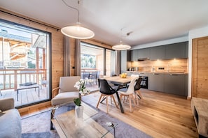 Cozinha moderna com armários de madeira e um espaço de jantar com uma mesa grande e cadeiras.