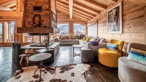 A spacious living area with a high wooden ceiling, a fireplace, and a sofa set. - Heavenly - Luxurious chalet with jacuzzi and sauna (Montriond)