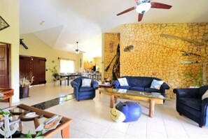 Relax in this inviting living area with a high ceiling, stone accent wall, and comfortable sofas.