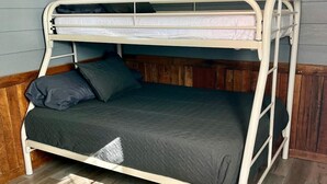 Un lit superposé avec une tête de lit en bois et un matelas de couleur foncée.
