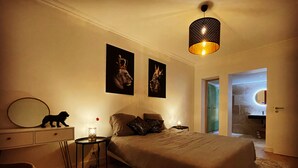 A bedroom with a bed, a bedside table, a lamp, a mirror, and two framed pictures on the wall. - la villa familiale la palmyre (Les Mathes)