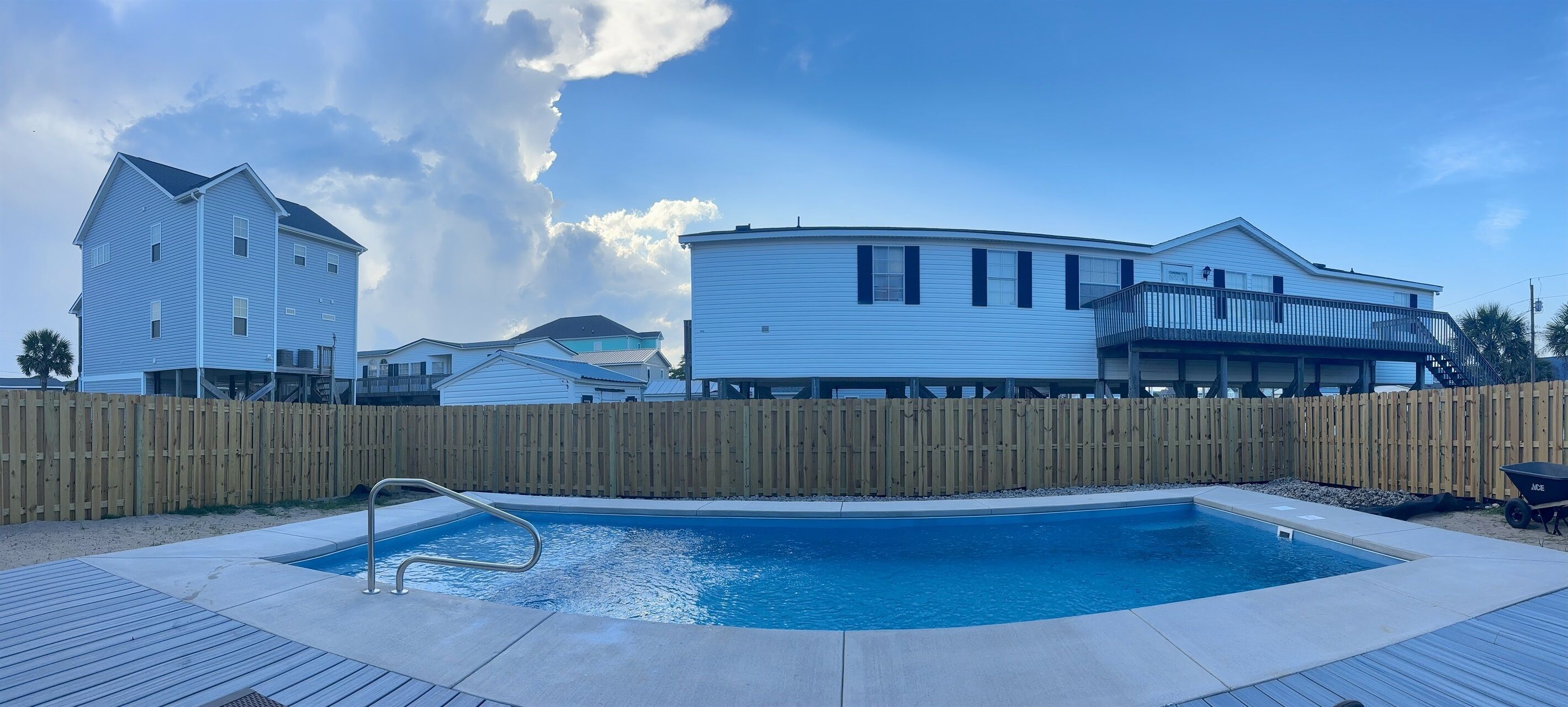 Ett bostadsområde med en swimmingpool, ett trädäck och hus med balkonger.