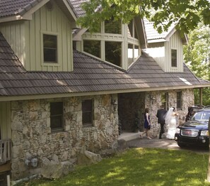 Une maison en pierre avec un toit à pignon et un porche.