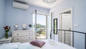 A bedroom with a bed, dresser, and a balcony with a view. - Villa with Swim/Heated Pool and charming Bay view (Zaton)