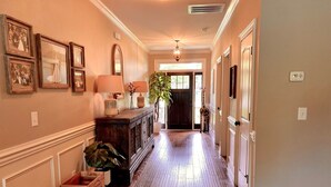 A hallway with wooden flooring, framed pictures on the walls, a lamp, and a potted plant. - Beautiful 5 BR, 3 BA, home only minutes away from the Masters and Peach Jam! (North Augusta)