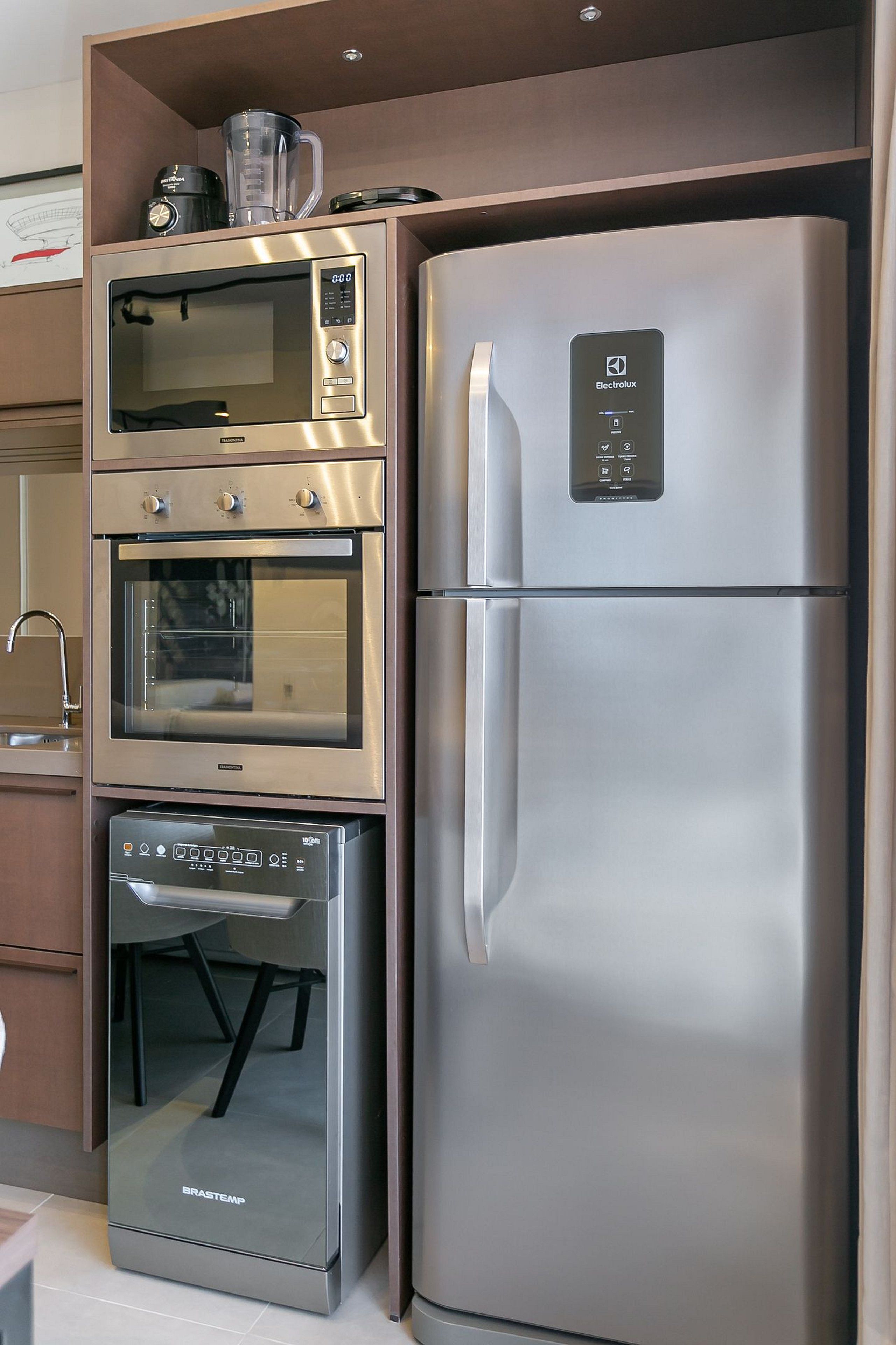 A kitchen with a built-in microwave, oven, and refrigerator.