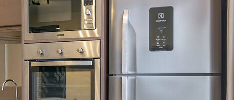 A kitchen with a built-in microwave, oven, and refrigerator.