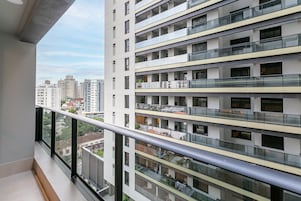 Un moderno edificio residenziale a più piani con balconi, ampie finestre e una vista aperta sulla città.
