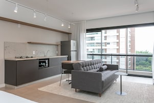 Un appartamento moderno con cucina, divano e ampie finestre.