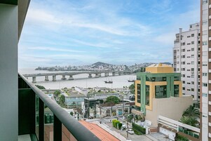 Un edificio alto con vista su un fiume e un ponte in lontananza.
