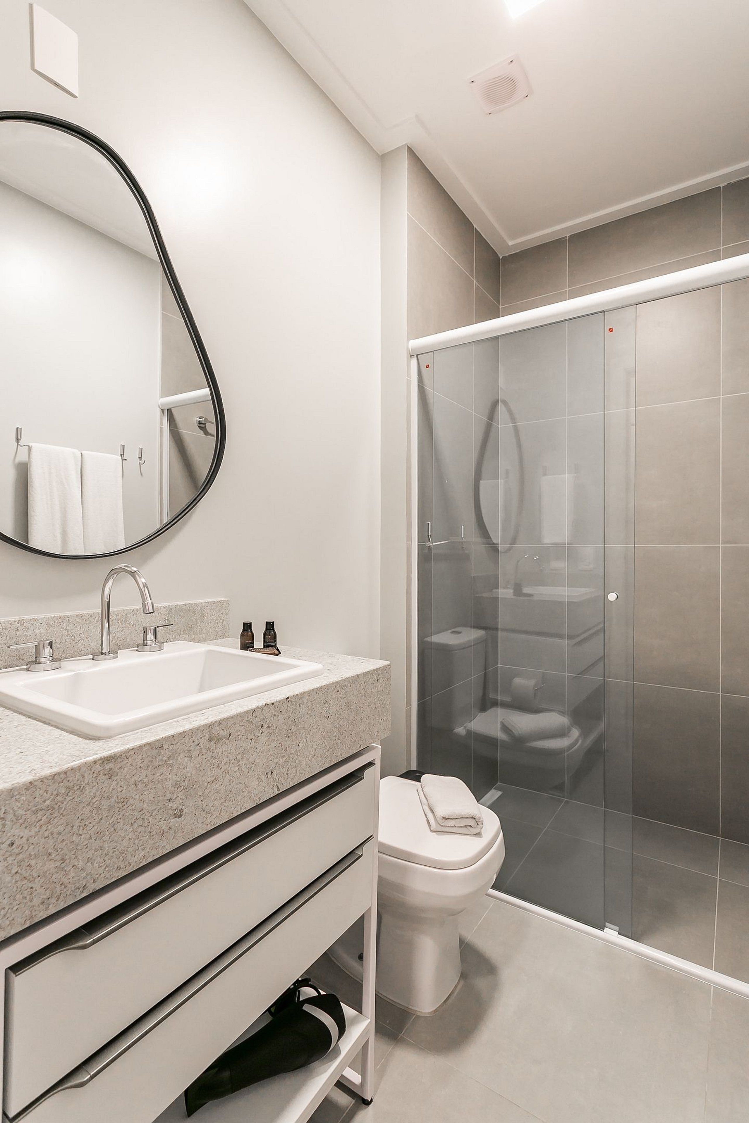 A modern bathroom with a double sink, a toilet, and a glass-enclosed shower.