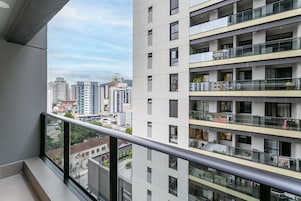 Un edificio residenziale alto con numerosi balconi, ampie finestre e vista sulla città.