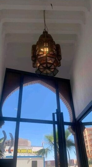 Enjoy the view from this room's large window, offering a glimpse of palm trees and a nearby building.