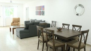 Un coin repas avec une table et des chaises en bois, un canapé et une table basse.
