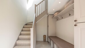 A staircase with carpeted steps, a wooden handrail, and a basket on the landing. - 2 bedroom accommodation in Broadway, near Cotswolds (Broadway, near Cotswolds)