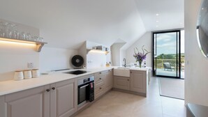 A modern kitchen with a built-in oven, a large window, and a view of the outdoors. - 2 bedroom accommodation in Broadway, near Cotswolds (Broadway, near Cotswolds)