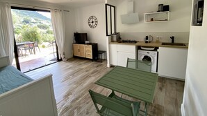 A compact kitchen with a dining area, a washing machine, and a view of the outdoors. - Appartement les Marines, Accès Plage à Pied. Vue Mer. Grande Terrasse (Casaglione)