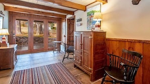 A wooden interior with a bench, a cabinet, and a door leading outside. - Lakefront | Firepit | Private Dock | Charming Home (Hot Springs)