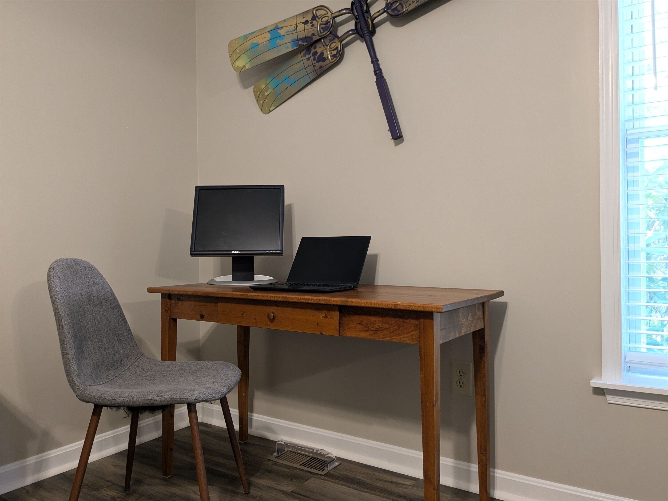 A workspace with a desk, chair, laptop, and monitor.