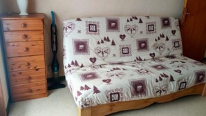 A bedroom with a bed, a wooden dresser, and a lamp. - Appartement au Pied des Pistes du Col du Rousset (Saint-Agnan-en-Vercors)