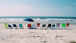 Een strand met rijen strandstoelen en parasols.