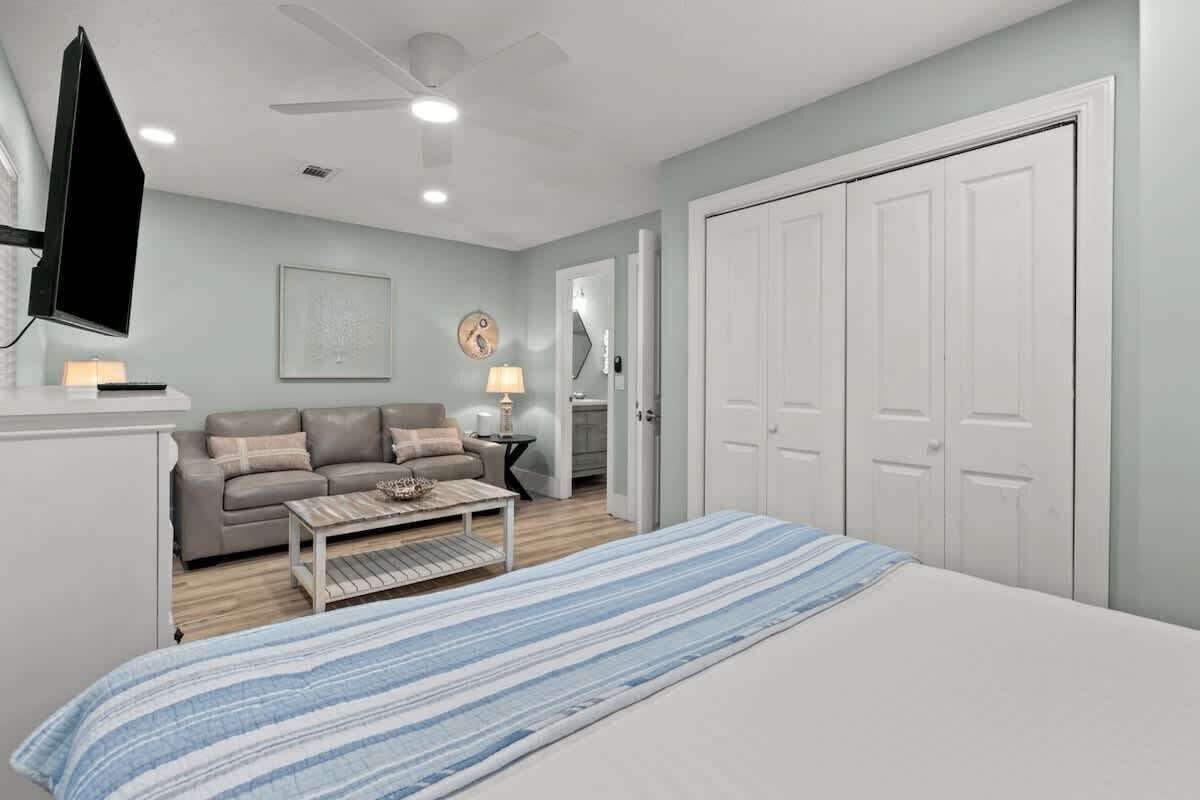 A bedroom with a bed, a sofa, a coffee table, a TV, and a wardrobe.