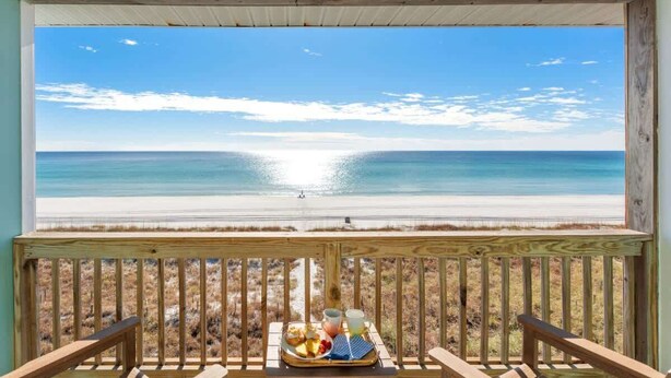 A wooden deck with a view of a beach and ocean. - Beachfront, Pool, Amazing Views, and Sleeps 14 (Panama City Beach)