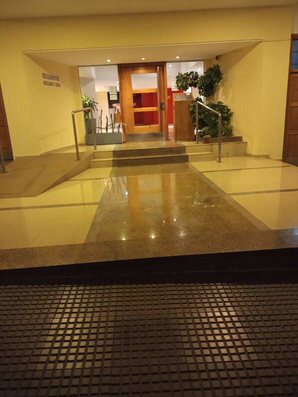 Stairs lead to a door at the top, with a potted plant nearby.