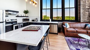 Una cocina moderna con una isla grande, electrodomésticos de acero inoxidable y vistas amplias a través de grandes ventanales.