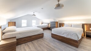 Un dormitorio moderno con dos camas, cabeceros de madera y un techo inclinado con iluminación empotrada.