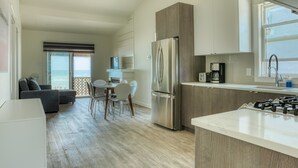 Une cuisine moderne équipée d’une cuisinière intégrée, d’un réfrigérateur et d’un coin repas avec une table et des chaises.