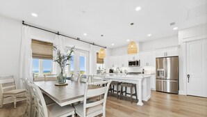 A modern kitchen with white cabinetry, stainless steel appliances, and a large island. - Grand Retreat I! 4BR 5BA Sleeps 15! Private Pool! Luxury and Comfort Await! (Panama City Beach)