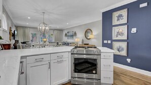 A modern kitchen with white cabinetry, a stainless steel oven, and a wooden countertop. - Award-Winning Resort Amenities | Grand Pavilion 24 (Isle of Palms)