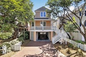 A two-story house with a front porch, a covered walkway, and a staircase leading to the second floor.