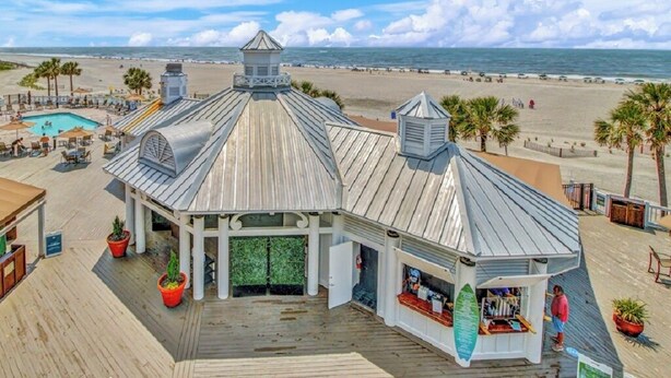 Ein Gebäude am Strand mit Pool, Bar und Blick auf den Ozean.