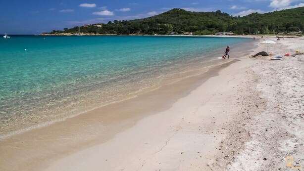 A beach with clear turquoise water, a sandy shore, and a hilly background. - Villa Pietra Avec Piscine Privée à 300 Mètres de la Plage (Conca)