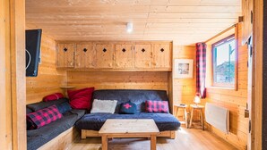 Ein gemütliches Blockhaus-Interieur mit einer Couch, einem Holztisch und einem Fenster mit Blick.
