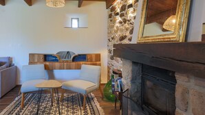 Una sala de estar acogedora con chimenea, una pared de piedra y un moderno conjunto de sofás.