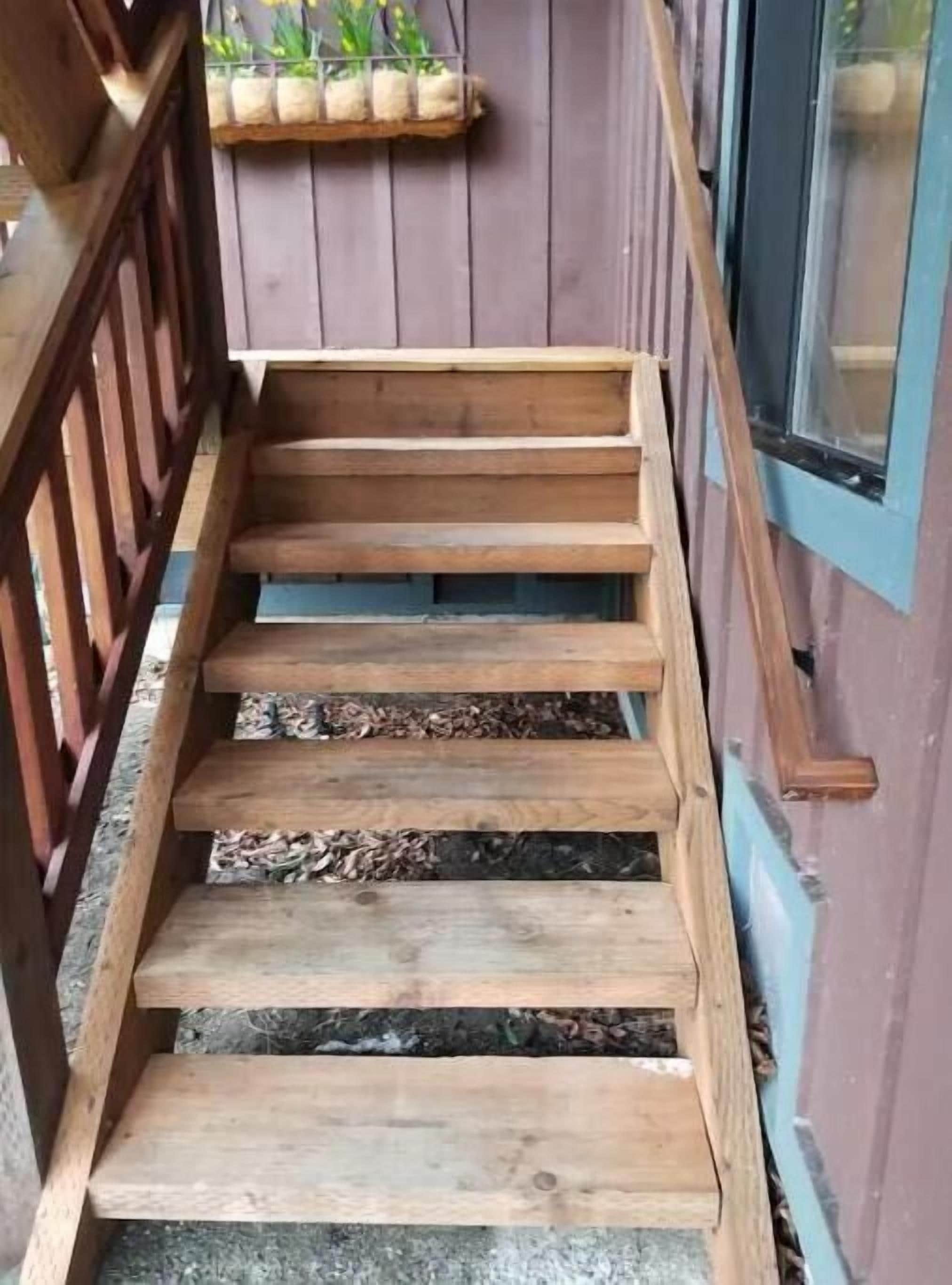 A wooden staircase leading to a door with a window.