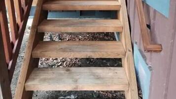 A wooden staircase leading to a door with a window.