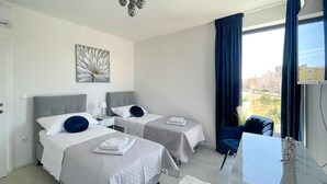 A hotel room with two beds, a desk, a chair, a TV, and a window with curtains. - Cozy home in Vodice with sauna (Vodice)