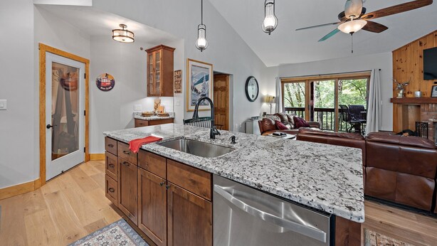 A kitchen with granite countertops, wooden cabinets, and a stainless steel dishwasher. - Labor Day openings! (Woodstock)