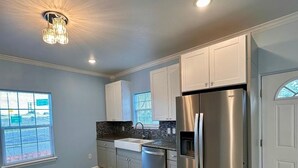 A kitchen with a stainless steel refrigerator, a dishwasher, and a sink. - A Gem off of IH-10  (San Antonio)